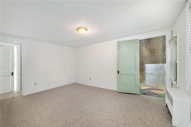 unfurnished bedroom featuring carpet floors and radiator heating unit