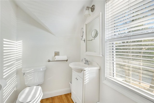 bathroom featuring hardwood / wood-style flooring, vanity, a healthy amount of sunlight, and toilet