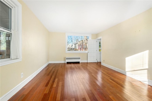 unfurnished living room with radiator and hardwood / wood-style flooring