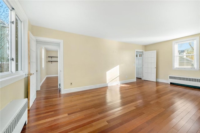 empty room featuring radiator heating unit and light wood-type flooring