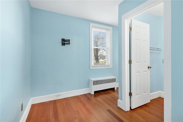 corridor featuring hardwood / wood-style flooring and radiator