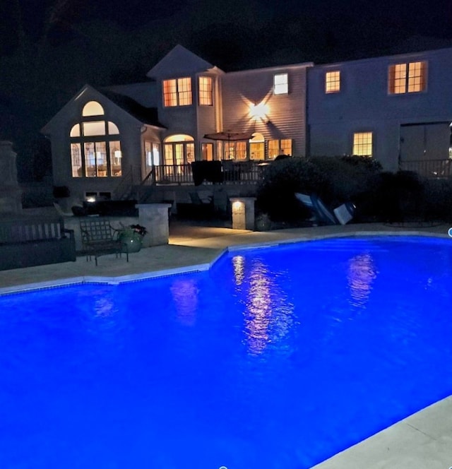 view of pool at twilight