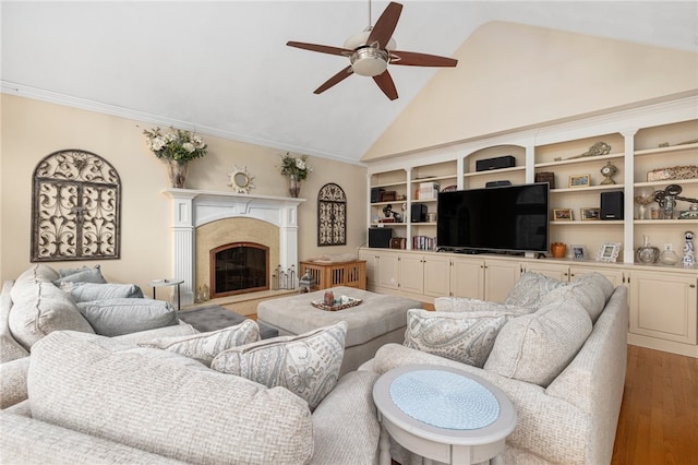 living room featuring ceiling fan, hardwood / wood-style flooring, high vaulted ceiling, and ornamental molding