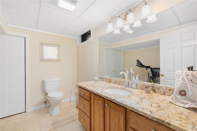 bathroom featuring vanity, a paneled ceiling, toilet, and tile patterned floors