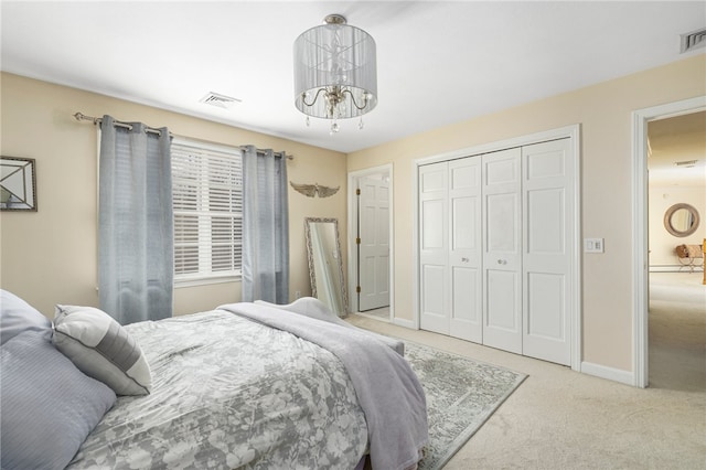 carpeted bedroom with a notable chandelier and a closet