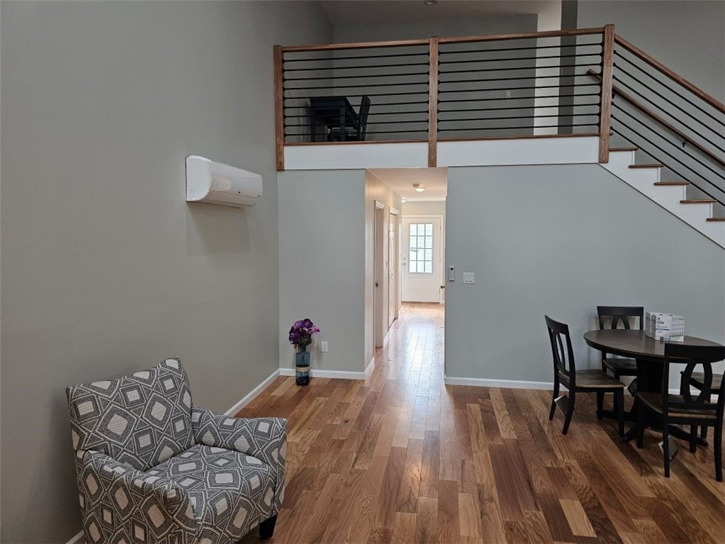 dining area with an AC wall unit and hardwood / wood-style flooring