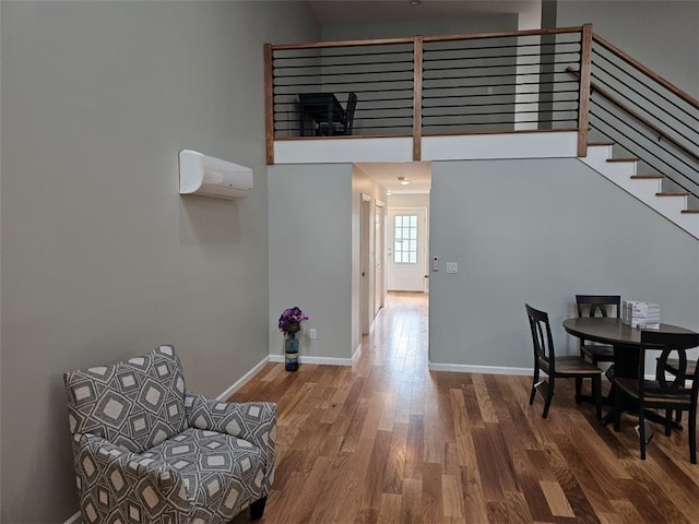 dining area with an AC wall unit and hardwood / wood-style flooring