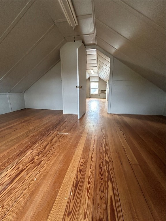 additional living space featuring hardwood / wood-style floors and vaulted ceiling