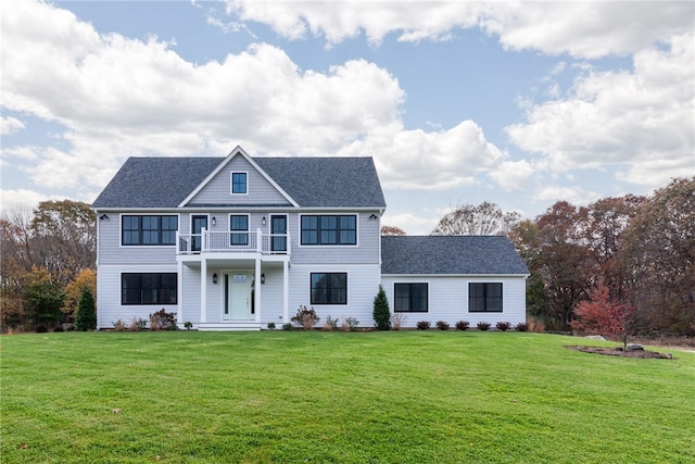 view of front of house featuring a front yard and a balcony