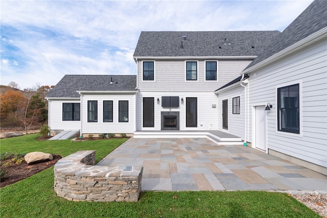 back of house with a patio and a lawn