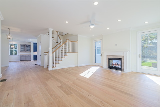 unfurnished living room with crown molding, light hardwood / wood-style flooring, a multi sided fireplace, and ceiling fan