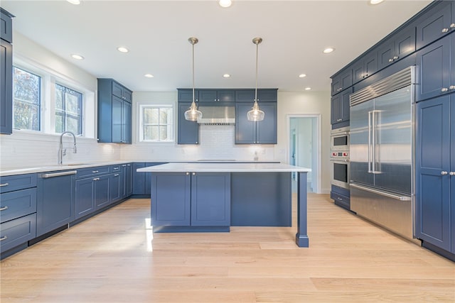 kitchen with backsplash, light hardwood / wood-style flooring, stainless steel appliances, pendant lighting, and a center island