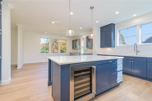 kitchen featuring backsplash, a kitchen island, light hardwood / wood-style floors, and beverage cooler