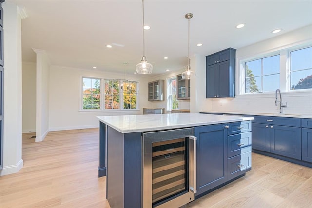 416 Bridgetown Rd, South Kingstown, RI 02874 - kitchen featuring beverage cooler, light countertops, a sink, light wood-style flooring, and backsplash