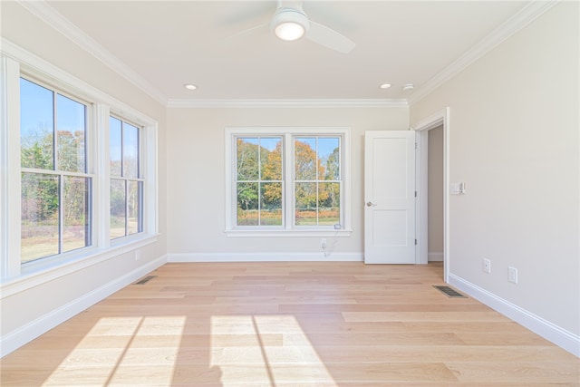 spare room featuring crown molding, light hardwood / wood-style floors, and plenty of natural light