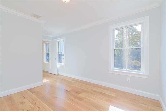 empty room with light hardwood / wood-style floors and crown molding