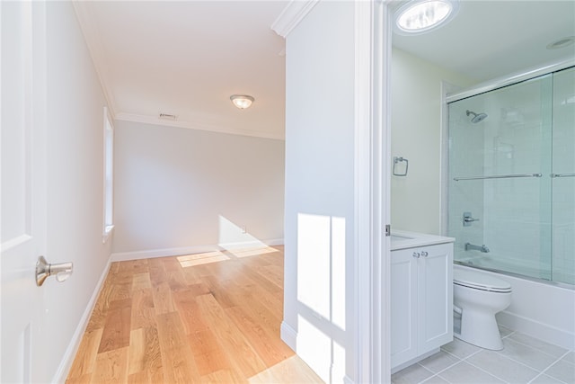 full bathroom with combined bath / shower with glass door, toilet, vanity, hardwood / wood-style flooring, and ornamental molding