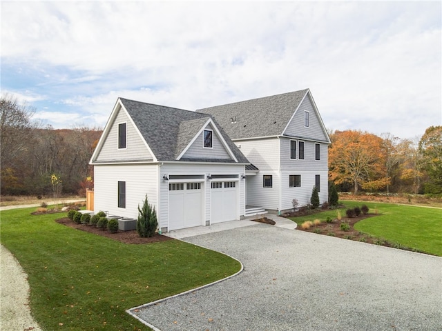 view of front of house with central air condition unit, a front yard, and a garage