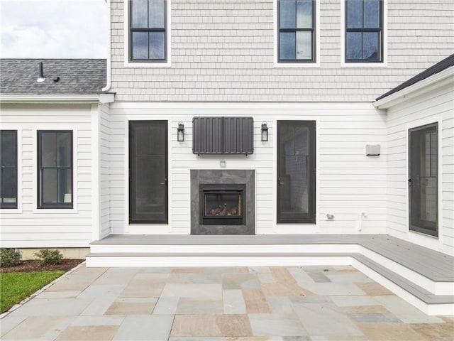 416 Bridgetown Rd, South Kingstown, RI 02874 - view of exterior entry featuring an outdoor fireplace and a patio