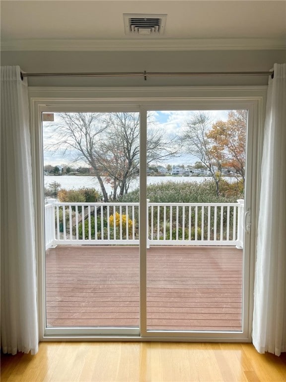 doorway to outside featuring light hardwood / wood-style floors, a healthy amount of sunlight, and ornamental molding