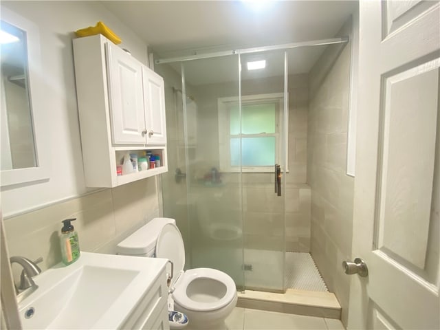 bathroom featuring a shower with door, backsplash, toilet, tile patterned floors, and vanity