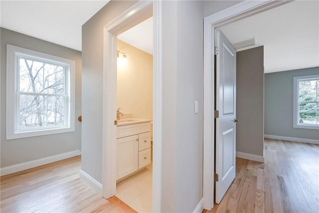 hall with sink and light hardwood / wood-style flooring