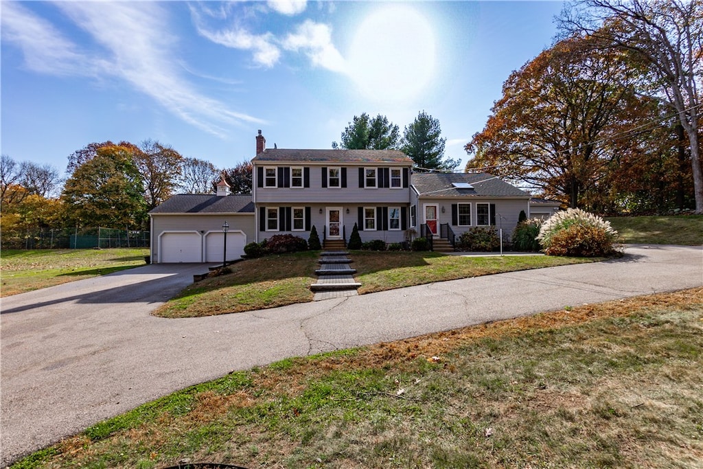 colonial home with a front yard and a garage