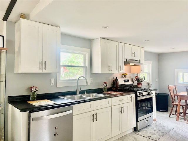 kitchen with sink, white cabinets, stainless steel appliances, and light wood-type flooring