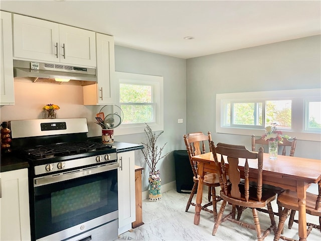 kitchen featuring plenty of natural light, white cabinetry, and gas range