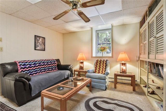 living room featuring baseboard heating, a drop ceiling, carpet, and ceiling fan