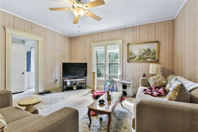 carpeted living room featuring ornamental molding and ceiling fan