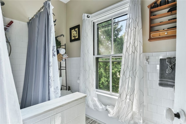 bathroom with tile walls and curtained shower