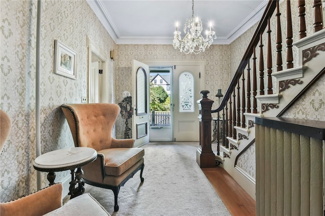 foyer entrance with crown molding, hardwood / wood-style flooring, and a notable chandelier