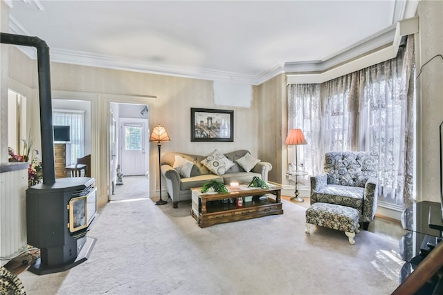 living room featuring a wood stove, carpet flooring, and crown molding