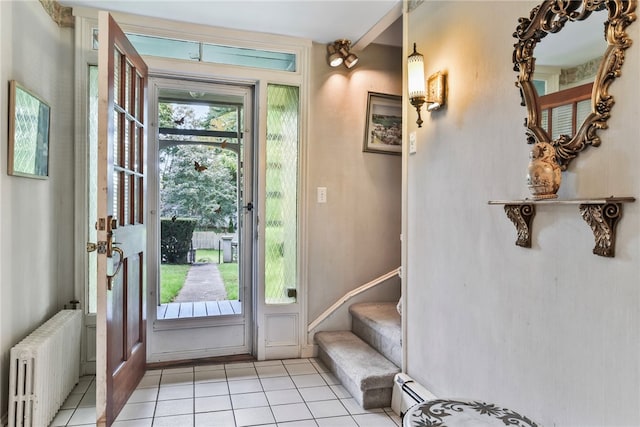 entryway featuring a baseboard radiator, light tile patterned flooring, and radiator heating unit