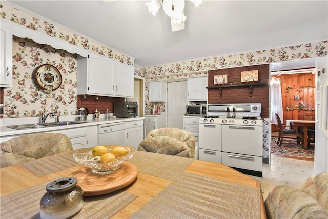 kitchen featuring white appliances, sink, ceiling fan, white cabinets, and decorative backsplash