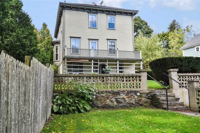 rear view of property featuring a lawn