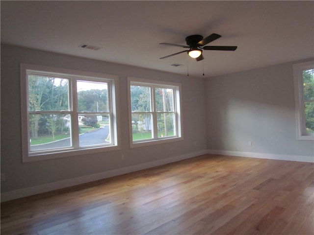 unfurnished room with light wood-type flooring, plenty of natural light, and ceiling fan