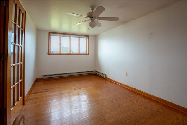 spare room featuring a baseboard radiator, light wood-type flooring, and ceiling fan