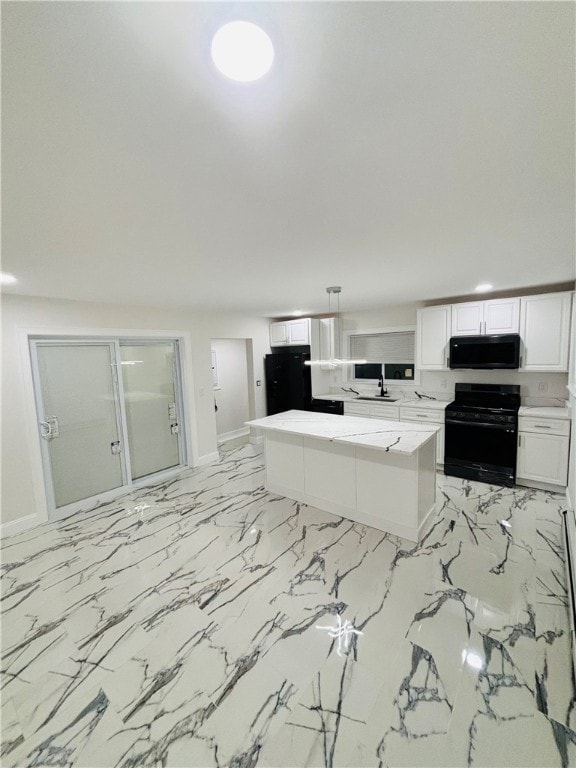 kitchen with black appliances, white cabinetry, light stone countertops, hanging light fixtures, and sink