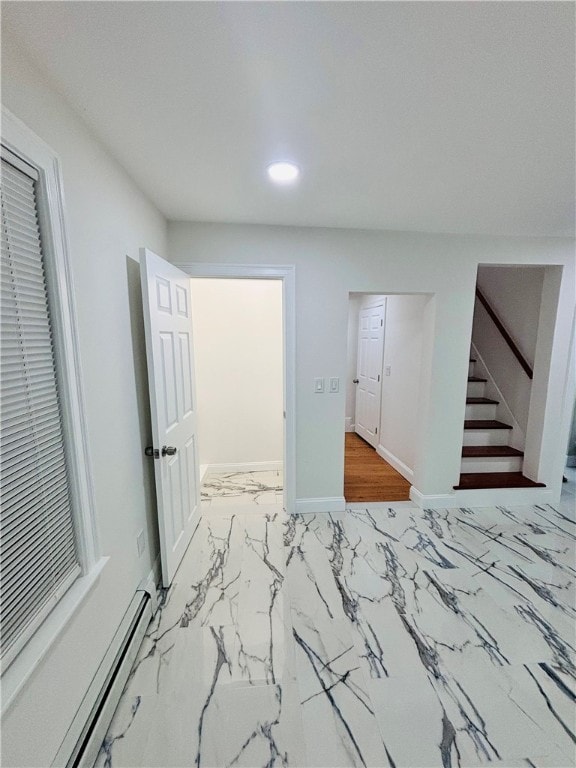 unfurnished bedroom featuring a baseboard radiator and a closet