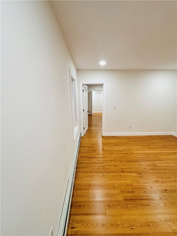 spare room with light hardwood / wood-style floors and a baseboard heating unit