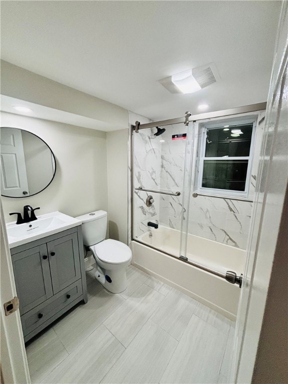 full bathroom with toilet, vanity, and bath / shower combo with glass door