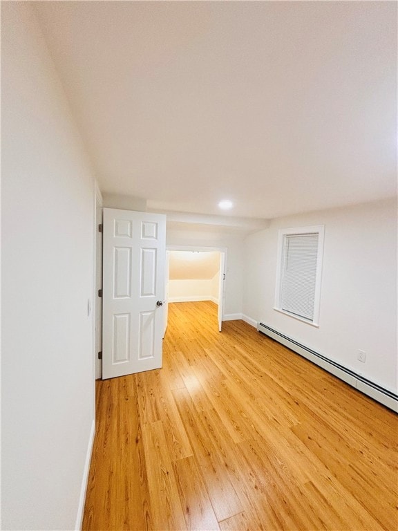 interior space with a baseboard radiator and light hardwood / wood-style flooring