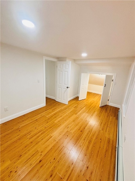 interior space featuring baseboard heating and light hardwood / wood-style floors