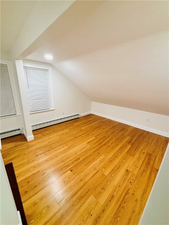 bonus room with vaulted ceiling, hardwood / wood-style flooring, and a baseboard radiator