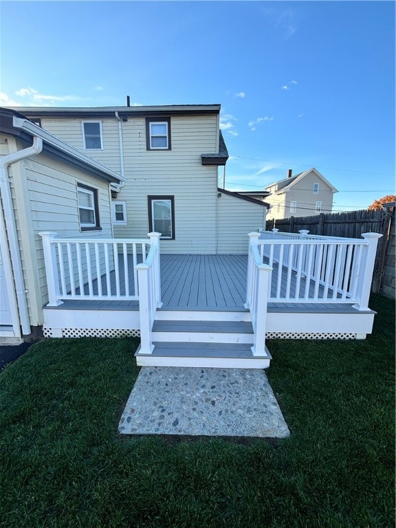 rear view of property featuring a lawn and a deck