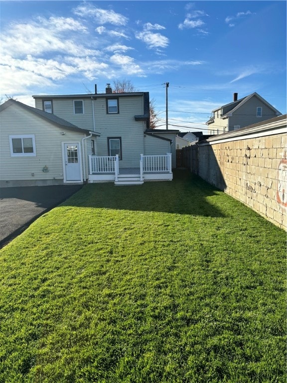 rear view of property with a yard and a deck