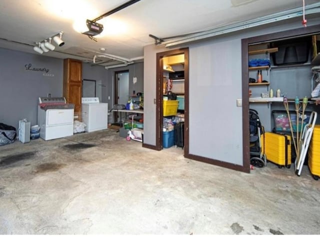 garage with a garage door opener and washing machine and dryer