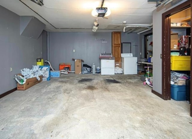 garage with separate washer and dryer and a garage door opener